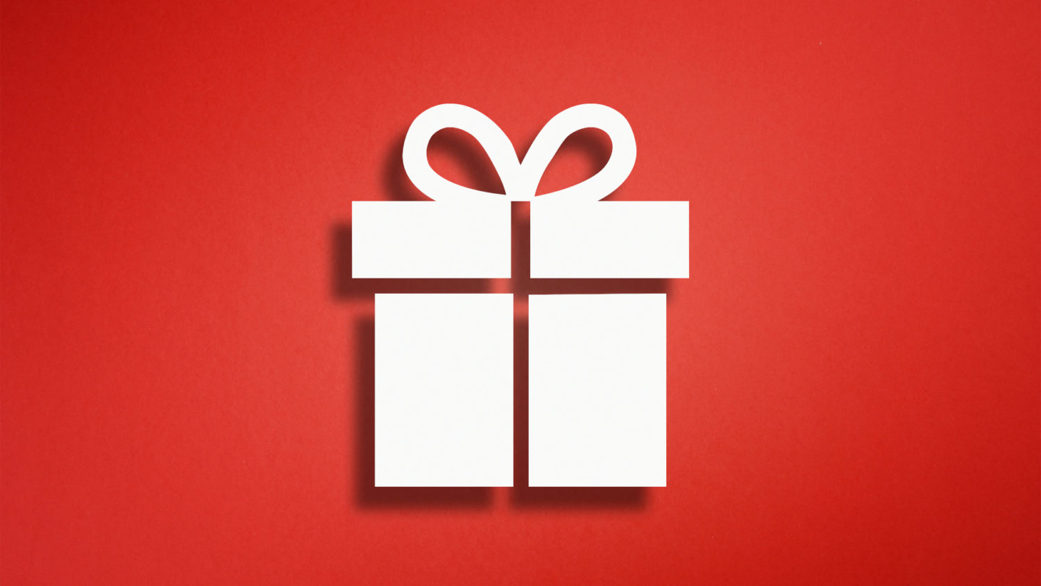 Verpacktes Geschenk mit Schleifchen vor rotem Hintergrund als Metapher für eine Value Proposition